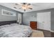 Bedroom with gray walls, hardwood floors, white shutters, a ceiling fan, and a comfortable queen bed at 72 Griggs Sw St, Marietta, GA 30064