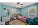 Bright bedroom with turquoise walls, plush accents, natural light from shuttered windows, and a ceiling fan at 72 Griggs Sw St, Marietta, GA 30064