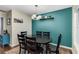 Dining room with a dark wood table, six chairs, colorful rug, and teal accent wall at 72 Griggs Sw St, Marietta, GA 30064