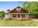 Charming home featuring a covered front porch with wooden porch swings, stone supports and a landscaped yard at 72 Griggs Sw St, Marietta, GA 30064