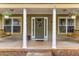 Inviting front porch with wooden porch swings, white columns, and a decorative front door with floral wreath at 72 Griggs Sw St, Marietta, GA 30064