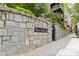 Stone wall entrance featuring 'The Dakota' sign, adding charm and curb appeal to the building's facade at 850 Piedmont Ne Ave # 1409, Atlanta, GA 30308