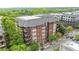 Charming brick condo building with a gray roof and multiple balconies surrounded by lush green trees at 850 Piedmont Ne Ave # 1409, Atlanta, GA 30308