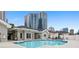 Community pool surrounded by lounge chairs, greenery, and a view of the city skyline at 850 Piedmont Ne Ave # 1409, Atlanta, GA 30308