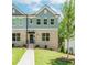 Charming townhome with a brick facade, manicured lawn, and inviting entrance with black door and awning at 1230 Ainsworth Aly # 34, Sugar Hill, GA 30518