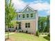 Charming townhome with a brick facade, manicured lawn, and inviting entrance with black door and awning at 1230 Ainsworth Aly # 34, Sugar Hill, GA 30518