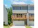 Rear exterior of townhome features a wooden deck above the garage and neutral siding at 1230 Ainsworth Aly # 34, Sugar Hill, GA 30518