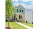 Charming townhome with a brick facade, manicured lawn, and inviting entrance with black door and awning at 1230 Ainsworth Aly # 34, Sugar Hill, GA 30518