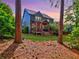 Expansive backyard featuring a covered porch area, verdant lawn, and mature trees at twilight at 2859 Seagrave Way, Marietta, GA 30066