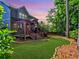 Lush backyard with covered deck, manicured lawn, and a border of trees, perfect for outdoor living at 2859 Seagrave Way, Marietta, GA 30066