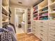 Spacious walk-in closet features custom shelving and a clothing rack with hardwood floors at 2859 Seagrave Way, Marietta, GA 30066