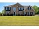 Two-story brick home with a well-manicured lawn and black shutters on the windows at 9482 Deer Crossing Ln, Jonesboro, GA 30236