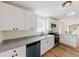 Bright kitchen features white cabinets, granite counters, stainless steel appliances and a view to the living spaces at 9482 Deer Crossing Ln, Jonesboro, GA 30236
