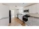 Modern kitchen features white cabinets, stainless steel appliances, and granite countertops, creating a sleek design at 9482 Deer Crossing Ln, Jonesboro, GA 30236