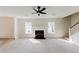 Living room features fireplace, ceiling fan, and staircase to the second level at 9482 Deer Crossing Ln, Jonesboro, GA 30236