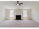 Open living room boasts neutral colors, large windows, and a cozy fireplace at 9482 Deer Crossing Ln, Jonesboro, GA 30236