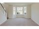 Spacious living room with bay windows providing natural light and plush carpeting at 9482 Deer Crossing Ln, Jonesboro, GA 30236