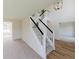 Elegant staircase with white railings and black accents, complemented by a modern chandelier at 9482 Deer Crossing Ln, Jonesboro, GA 30236