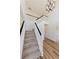 Bright foyer staircase featuring modern light fixture, carpeted stairs, and wood-look floors at 9482 Deer Crossing Ln, Jonesboro, GA 30236