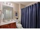 Bathroom features wood vanity with sink, toilet, and shower with blue curtain at 973 Duncan Ter, Canton, GA 30115