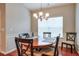 Well-lit dining room featuring a round wooden table, chandelier, and view from the window at 973 Duncan Ter, Canton, GA 30115