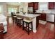 Stylish kitchen with an island offering barstool seating, stainless steel appliances, and red hardwood floors at 973 Duncan Ter, Canton, GA 30115
