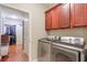 Functional laundry room with modern appliances, cherry cabinets, and access to a walk-in closet at 973 Duncan Ter, Canton, GA 30115
