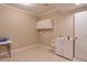 Bright laundry room featuring tile flooring, utility sink, and storage cabinets, next to a white door at 973 Duncan Ter, Canton, GA 30115