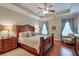 Spacious main bedroom with a tray ceiling, wooden furniture, and a comfortable armchair at 973 Duncan Ter, Canton, GA 30115