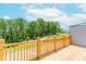 Backyard featuring a wood deck with wood railing and a view of the green space and trees at 1242 Ainsworth Aly # 40, Sugar Hill, GA 30518