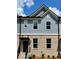 Charming two-story townhome with a brick and shingle exterior, complemented by well-manicured landscaping at 1242 Ainsworth Aly # 40, Sugar Hill, GA 30518