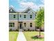 Charming townhome featuring a brick facade, well-manicured lawn, and inviting entryway at 1242 Ainsworth Aly # 40, Sugar Hill, GA 30518