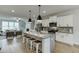 Stylish kitchen with stainless appliances, a large granite island with seating and open floor plan at 1242 Ainsworth Aly # 40, Sugar Hill, GA 30518