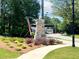 Stone signage marks the entrance to Hillcrest Landing, surrounded by colorful landscaping and lush greenery at 1242 Ainsworth Aly # 40, Sugar Hill, GA 30518
