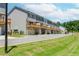 View of modern townhomes, each with a private wooden balcony and attached garage, from the rear at 1242 Ainsworth Aly # 40, Sugar Hill, GA 30518