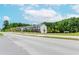 A street view shows a row of modern townhomes with manicured lawns and lush trees in a well-kept neighborhood at 1242 Ainsworth Aly # 40, Sugar Hill, GA 30518