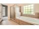 Luxurious bathroom featuring a soaking tub, separate shower, and tiled surround at 3580 Bulloch Lake Rd, Loganville, GA 30052