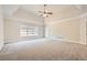 Expansive bedroom with a tray ceiling, plush carpet, and natural light at 3580 Bulloch Lake Rd, Loganville, GA 30052