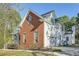 Side view of a two-story brick and white home with an attached garage and mature trees at 3580 Bulloch Lake Rd, Loganville, GA 30052