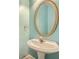 Stylish powder room with a pedestal sink and decorative oval mirror at 3580 Bulloch Lake Rd, Loganville, GA 30052