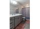 Well-lit bathroom with a gray vanity, shower-tub combination, and stylish accents at 360 Winston Cir, Canton, GA 30114