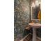 Stylish powder room featuring floral wallpaper, a pedestal sink, and elegant fixtures at 360 Winston Cir, Canton, GA 30114