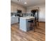 Modern kitchen boasts gray cabinets, stainless steel appliances, tile backsplash, and an island with bar stools at 360 Winston Cir, Canton, GA 30114