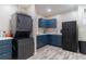 Compact kitchen with stacked laundry machines and updated blue cabinets and appliances at 360 Winston Cir, Canton, GA 30114