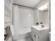 Well-lit bathroom with white tile, shower-tub combo, and classic vanity with storage at 4442 Freeman Rd, Marietta, GA 30062