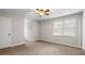 A carpeted bedroom featuring a ceiling fan and a window letting in natural light at 4442 Freeman Rd, Marietta, GA 30062