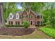 Charming two-story brick home with dormer windows, black shutters, and mature trees on a lush landscaped lot at 4442 Freeman Rd, Marietta, GA 30062