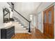 Elegant foyer with hardwood floors, staircase with black and white accents, and beautiful wood front door at 4442 Freeman Rd, Marietta, GA 30062