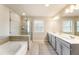 Gorgeous bathroom featuring a soaking tub, glass shower, double vanity with sleek countertops and updated fixtures at 120 Maple Creek Way, Woodstock, GA 30188