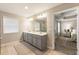 Bright bathroom with double sink vanity, modern lighting, and a glimpse into the main bedroom at 120 Maple Creek Way, Woodstock, GA 30188